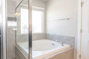 Full bath featuring a garden tub and a stall shower