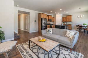 Living area with dark wood-style floors and hanging lights