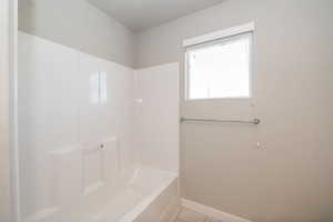 Bathroom featuring light tile patterned floors and shower / tub combination