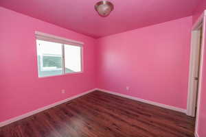 Unfurnished room with dark wood-type flooring and a textured ceiling