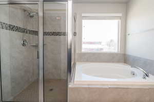 Bathroom featuring a shower stall and a bath