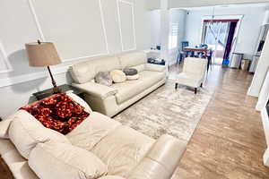 Living area featuring light wood-style flooring and suspended lighting