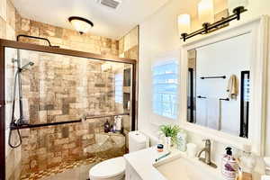 Full bath featuring vanity, a shower stall, and a textured ceiling