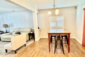 Dining room with a chandelier, wood finished floors, and a textured ceiling