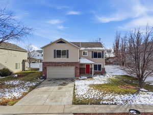 Traditional-style house featuring brick siding, concrete driveway, and an attached garage