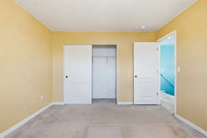 Bedroom with light carpet and a closet