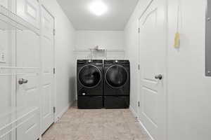 Laundry room featuring washer and clothes dryer and stone finish flooring