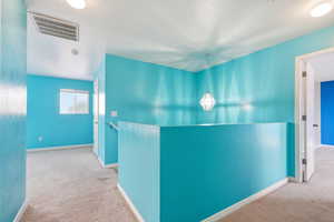 Corridor featuring carpet floors and an upstairs landing