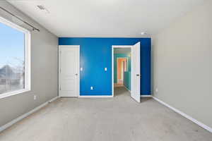 Unfurnished bedroom with carpet flooring and baseboards