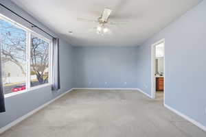 Primary Bedroom with a ceiling fan and light-colored carpet