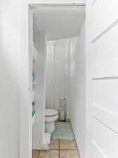 Bathroom with tile patterned flooring and a textured wall