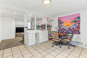 Office area featuring a baseboard heating unit, light tile patterned floors, and light carpet