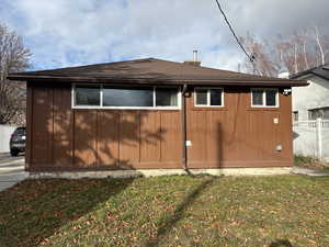 View of side of home with roof with shingles and board and batten siding