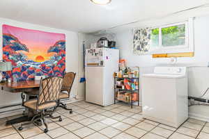 Dining area featuring washer / dryer and light tile patterned floors