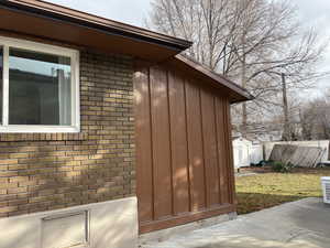 View of side of home with brick siding and board and batten siding