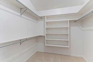 Walk in closet with light carpet