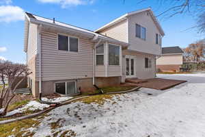 Snow covered rear of property with french doors