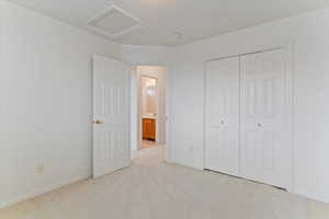 Unfurnished bedroom featuring light carpet and a closet