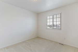 Spare room with light carpet and baseboards