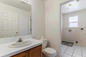 Half bathroom with vanity and light tile patterned floors