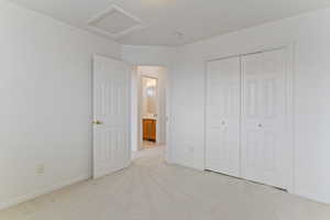 Unfurnished bedroom with light carpet and a closet