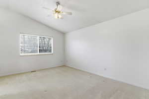 Unfurnished room with carpet, a ceiling fan, and vaulted ceiling