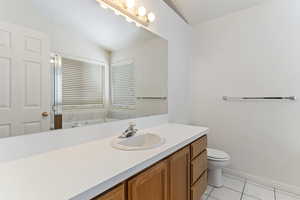 Full bathroom featuring vanity, light tile patterned flooring, and lofted ceiling