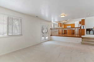 Empty room with light colored carpet and lofted ceiling