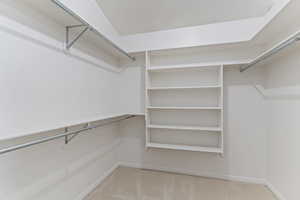Walk in closet featuring light colored carpet