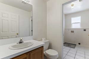 Half bathroom featuring vanity and light tile patterned floors