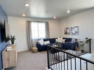 Living area featuring light colored carpet and recessed lighting