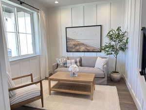 Sitting room with a decorative wall, wood finished floors, and recessed lighting