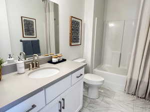 Bathroom featuring vanity, shower / bathtub combination with curtain, and light marble finish flooring