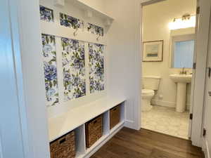Half bathroom with toilet and dark wood-style flooring