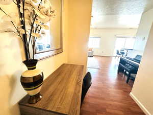Corridor featuring dark wood-type flooring and a textured ceiling