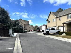 View of asphalt road with a residential view, curbs, and sidewalks