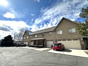 View of front facade featuring stone siding, concrete driveway, stucco siding, and a garage