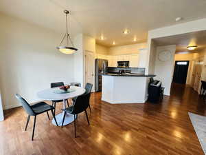 Dining space with dark wood-type flooring and baseboards