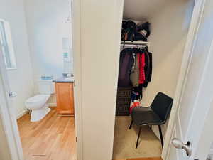 Walk in closet with light wood-style floors
