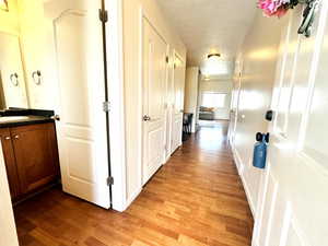 Hall with light wood-style flooring and a textured ceiling