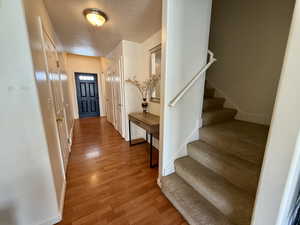 Foyer entrance with stairs and light wood-style floors