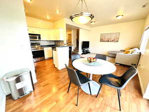 Dining room with stairs and light wood-type flooring