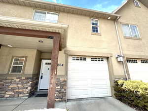Doorway to property with stucco siding and an attached garage