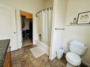 Bathroom featuring vanity, a spacious closet, and shower / bath combination with curtain