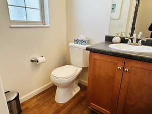 Half bath with vanity and dark wood finished floors