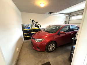 Garage featuring baseboards and a garage door opener