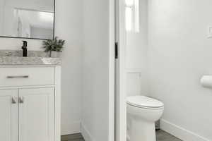 Half bathroom with vanity and wood finished floors