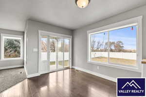 Unfurnished dining area featuring dark wood-style flooring and baseboards