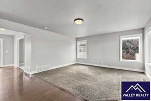 Family room with baseboards and dark wood-style flooring