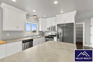 Kitchen featuring white cabinets, stainless steel appliances, and recessed lighting